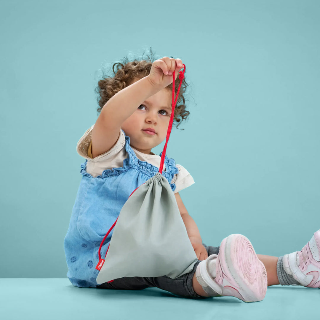 Toddler holding Alpine Muffy Baby storage bag