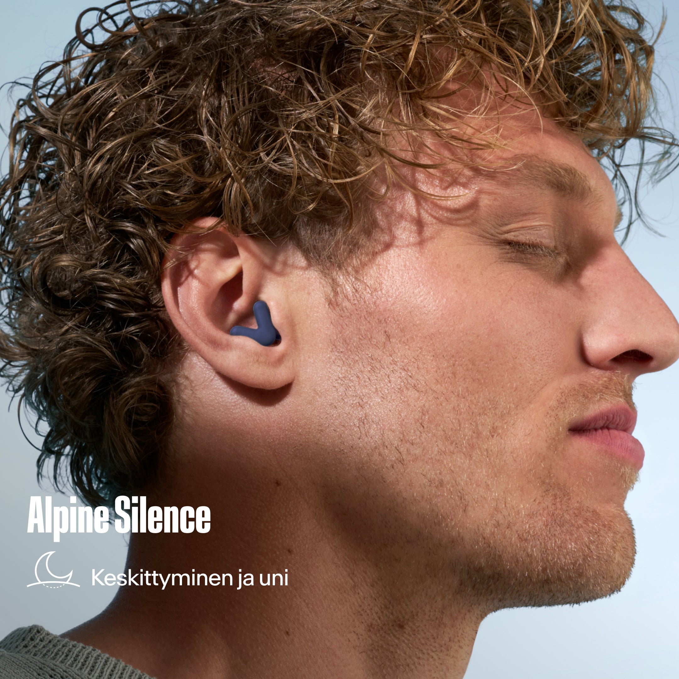 Alpine Silence -korvatulppa kiharatukkaisen miehen korvassa, tekstinä &