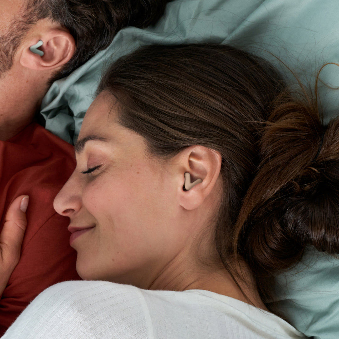 Man and woman sleeping, wearing Alpine Silence earplugs in beige that stay securely in place 